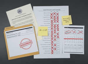 Documentary-style flat-lay on a federal education administrator's desk. Center: an org chart for the Institute of Education Sciences showing a column of staff positions — most are crossed out with red X marks, leaving only a handful remaining. A sticky note on the chart reads "191 → 28." To the left, a memo from the Department of Education dated March 2025 with the subject line "Reduction in Force and Reorganization." Beside it, an internal project file labeled "Enrollment Denominator Fix — FY2024" with a red stamp reading "DISCONTINUED." A printed calendar shows late 2024 with "Begin enrollment fix" marked, and 2025 with "RIF announced" marked and a line drawn through the rest. A sticky note reads: "Due to staffing changes at the agency." The overall mood is institutional capacity quietly disappearing — not dramatic, just empty chairs. Muted government palette — cream, gray, federal blue, red X marks, fluorescent light.